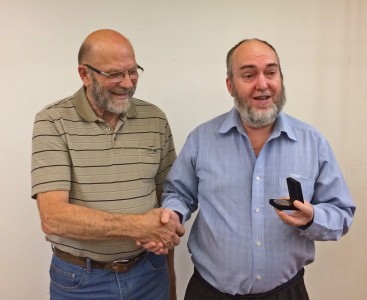 Neil (left) presents the Medal to Richard (right).